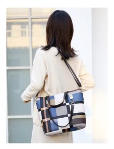 Detail of checkered tote bag with blue and brown patterns and adjustable shoulder strap