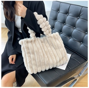 Détail du sac cabas en fausse fourrure beige avec texture plissée et anses tressées