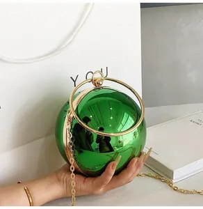Macro shot of green metallic spherical evening clutch with gold circular ring handle
