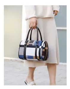 Detail shot of a plaid cylinder handbag featuring a textured multi-color checkered pattern