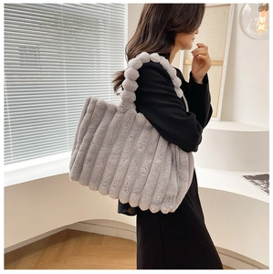 Détail du sac cabas gris en peluche avec poignée pompon et texture fausse fourrure