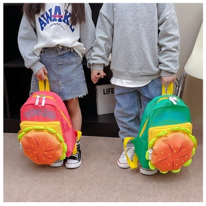 Détail de sacs à dos colorés style hamburger tenus par des enfants dans une pièce moderne