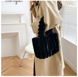 Détail du sac cabas en peluche noire avec rayures texturées et poignée en fausse fourrure