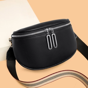 Sac banane en cuir grainé noir avec bandoulière rayée sur un support moderne