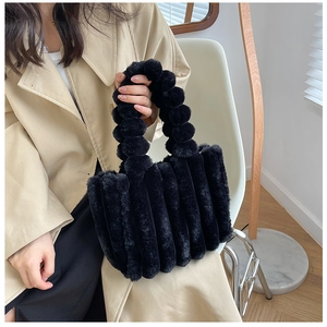 Détail du sac cabas en peluche noire avec texture plissée et poignée à boules douces