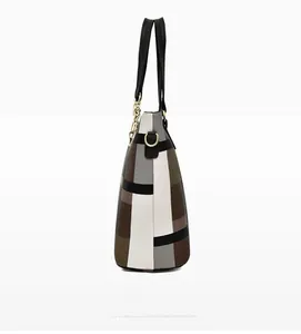 Detail view of the trapezoidal side profile and golden metal hardware of the tote bag