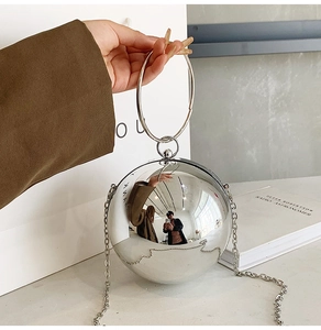 Spherical silver mirror clutch bag with round metal handle and long chain strap