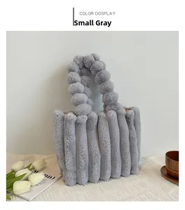 Détail du sac cabas en peluche grise avec texture rayée et bandoulière à pompons