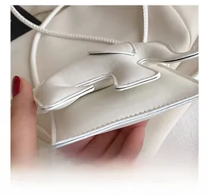 Détail du mini sac éléphant en cuir blanc montrant les coutures fines et l'artisanat