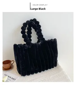 Détail du grand sac cabas noir en peluche avec poignée en boules et texture rayée