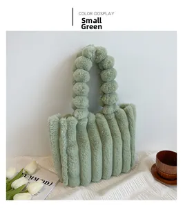 Détail du sac cabas en peluche vert sauge avec rayures verticales et poignée pompon