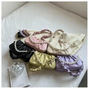 Close-up of pleated cloud bags in multiple colors with elegant pearl chain decorations