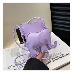 Détail de la pochette téléphone violette en forme d'éléphant sur un magazine