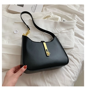 Close-up of black shoulder bag featuring gold vertical metal buckle and thick chain strap