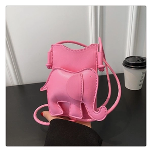 Gros plan du mini sac bandoulière éléphant rose en cuir sur fond minimaliste chic
