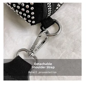 Nahaufnahme des abnehmbaren Metallhakens und der Strassdetails auf einer Wildledertasche