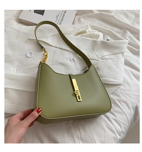 Close-up of matcha green hobo bag with gold chain strap and buckle on white fabric
