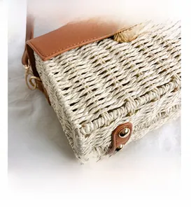 Close-up of woven straw texture with brown lychee leather trim and gold twist lock
