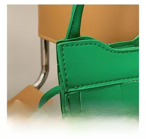 Detail showing high-quality woven craft and precision stitching on green leather bag