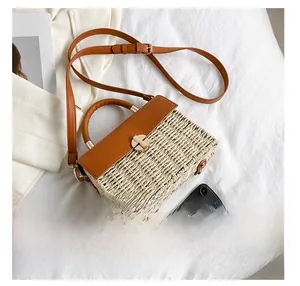 Size comparison of beige woven crossbody bag next to a smartphone for scale