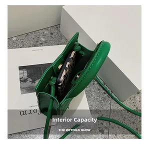 Internal capacity of green mini woven bag showing a smartphone with leopard case