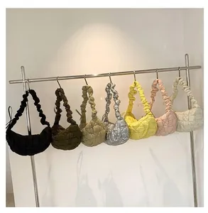 Close-up of quilted bubble hobo bags in seven colors hanging on a metal display rack