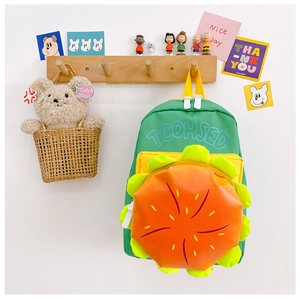 Détail d'un sac à dos enfant vert en forme de fleur avec poche orange sur crochet