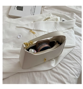 Detailed internal view of beige crescent bag showing phone and cosmetic storage capacity