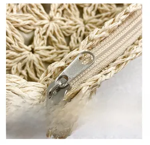 Détail macro d'un sac en paille tissé main montrant la texture et le zip métallique