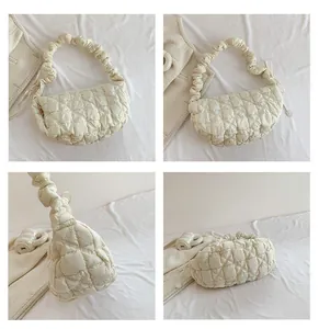 Detail view of cream white quilted cloud bag featuring scrunched handle and puffy texture