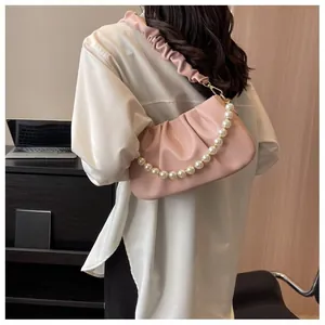 Detail of pink ruched cloud bag with decorative pearl chain and soft leather shoulder strap