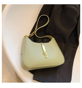 Detail of light green hobo bag featuring golden chain and metallic rectangular buckle