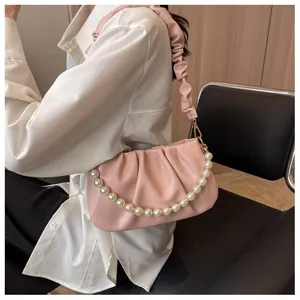 Close-up of pink ruched cloud bag with large imitation pearl chain and soft leather detail