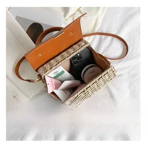 Detail presentation showing the spacious interior of a woven straw crossbody bag
