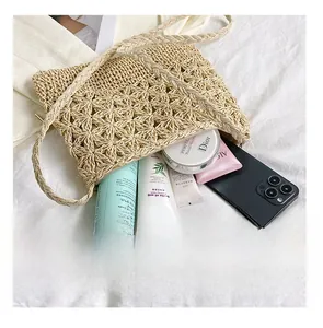 Détails d'un sac cabas en paille tissé à la main avec motifs floraux ajourés