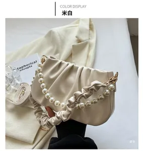 Detail of off-white ruched cloud bag featuring pearl chain and soft leather texture