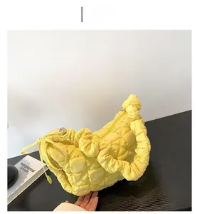 Macro detail of the yellow puffy cloud bag showing quilted bubble texture and chain strap