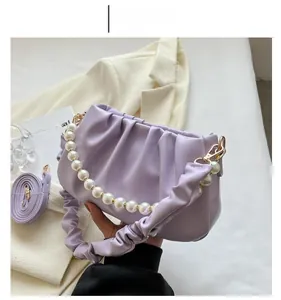 Detail of purple pleated cloud bag featuring pearl handle and soft PU leather texture