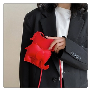 Détail du sac bandoulière éléphant rouge avec oreilles 3D sur un blazer noir élégant