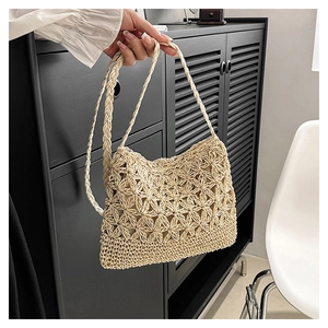 Détail du sac bandoulière en paille beige tissé main avec motif ajouré élégant