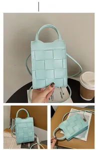 Close-up of mint blue woven leather mini phone bag with a checkered pattern and strap