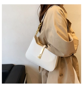 Detail of white leather underarm bag featuring a gold chunky chain and metallic lock