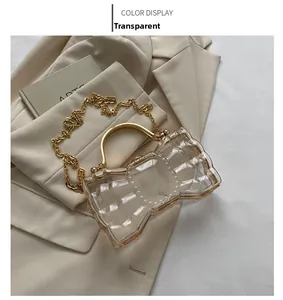 Détail du sac pochette nœud en acrylique transparent avec cadre et chaîne en métal doré