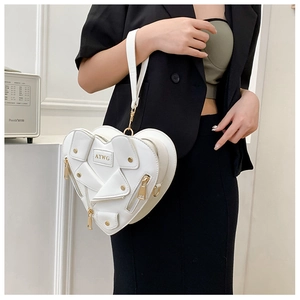 Close-up of white heart-shaped crossbody bag with gold zippers on a fashion model