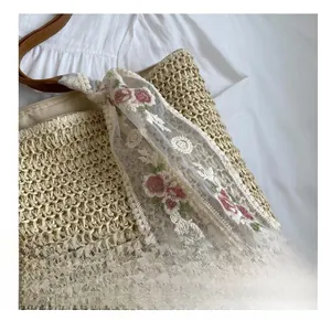 Detail of hand-woven beige tote bag with floral lace scarf decor and texture