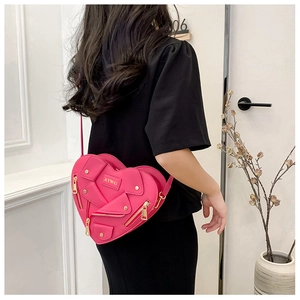Detail of rose pink heart-shaped crossbody bag featuring creative biker jacket design