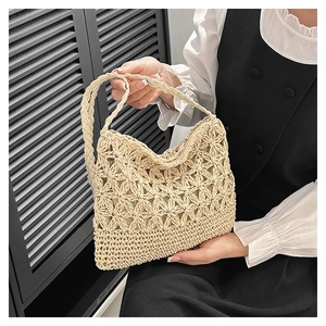 Détail du sac en paille beige tissé main avec des motifs d'étoiles ajourés complexes