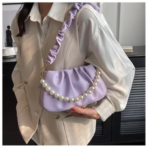 Close-up of lavender pleated cloud bag with elegant pearl chain and soft leather detail