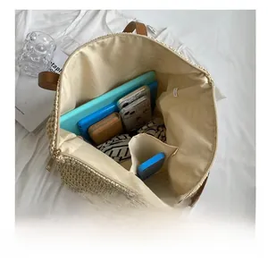 Spacious hand-woven straw tote bag showing internal storage for tablet and phone