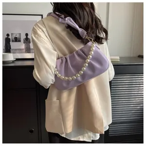 Detail of lavender pleated cloud bag featuring white pearl chain and soft scrunched strap